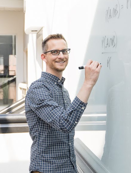 Brian writing a conditional probability formula on a whiteboard